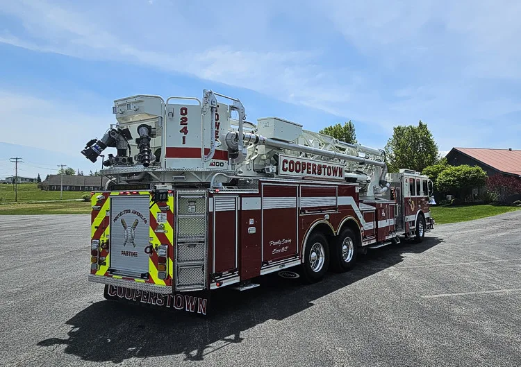 Rear-left exterior view showing ladder bed, turntable area, and rear chevrons