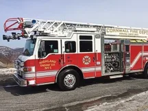 Tower ladder front-left exterior view showing enclosed cab and aerial sections
