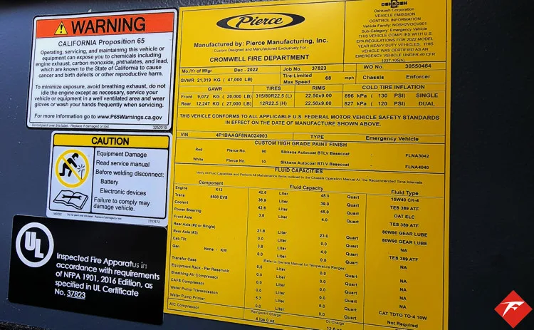 Cab door-jamb close-up showing yellow safety label and specification plate