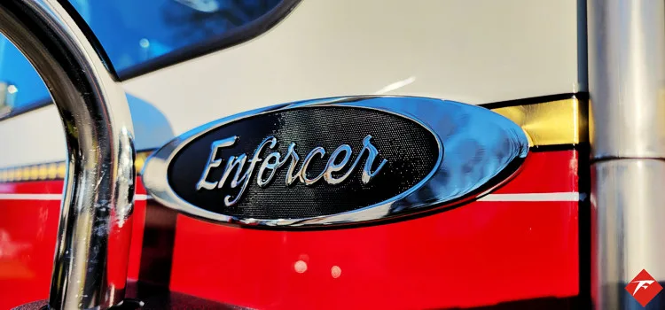 Body badge close-up showing Enforcer emblem on red panel
