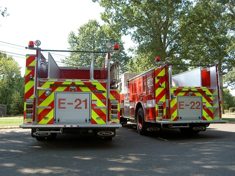 Rear view of two pumpers showing rear chevrons and hosebed panels