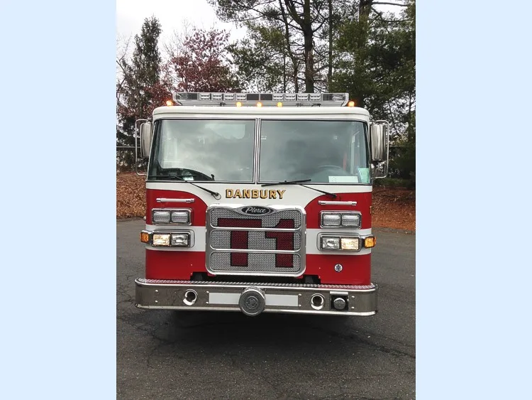 Head-on front view with warning lights active showing grille and bumper inlets