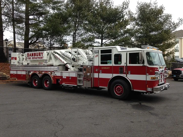 Passenger-side full profile showing ladder base, side compartments, and wheel layout