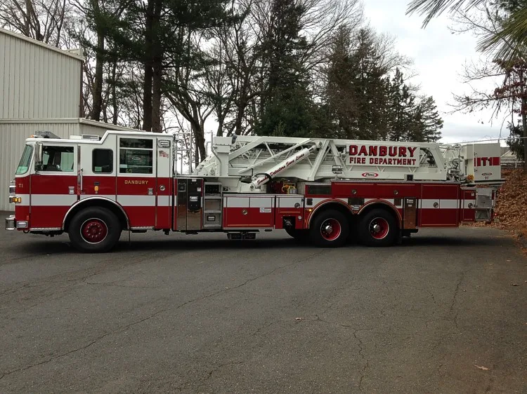 Driver-side profile view showing stowed ladder sections and mid-body controls
