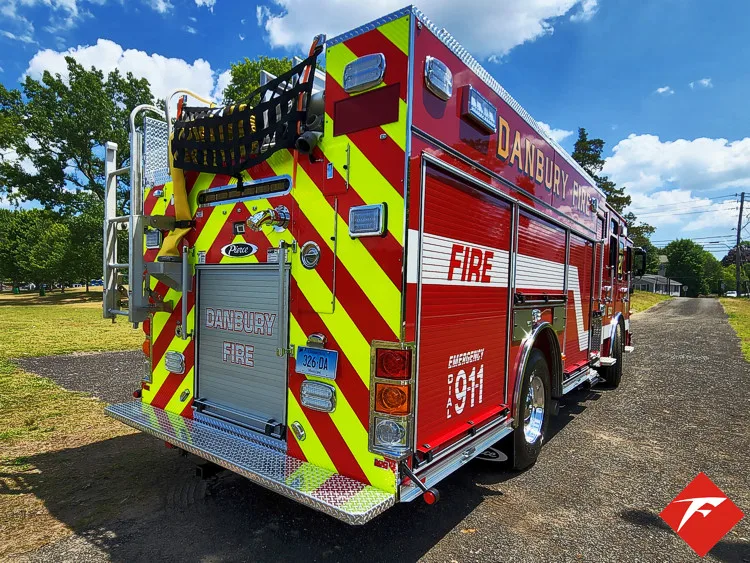 Rear-left exterior view showing chevrons, open rear compartment, and side body