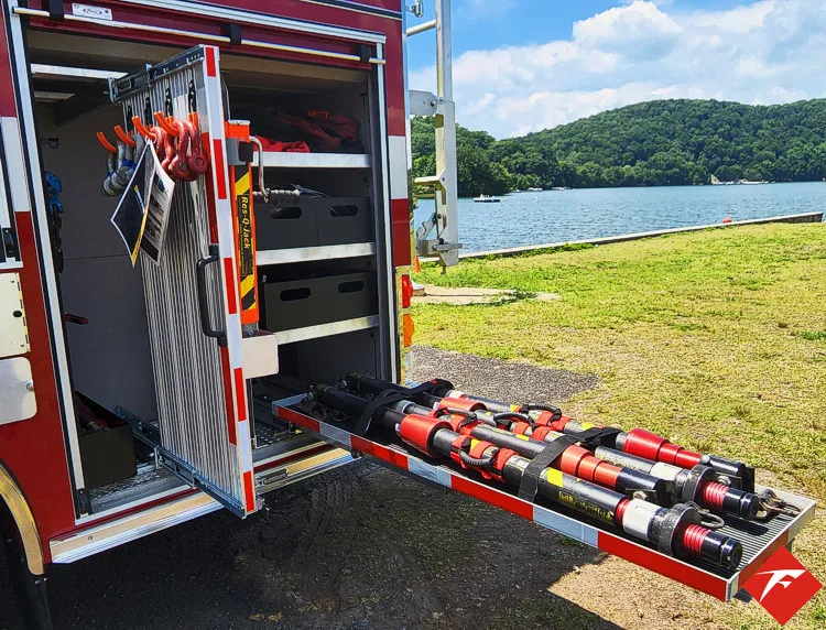 Open rear-side compartment showing slide-out tray with mounted rescue tools