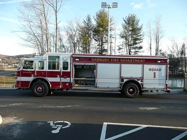 Full right-side profile showing roll-up compartment doors, wheel/tire area, and open side equipment bay.