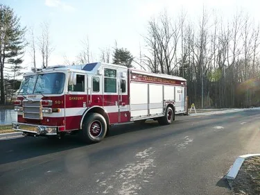 Front right side view from a distance showing cab, bumper, and long rescue body.