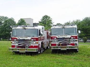 Front view of two pumpers parked side by side with grilles and bumpers