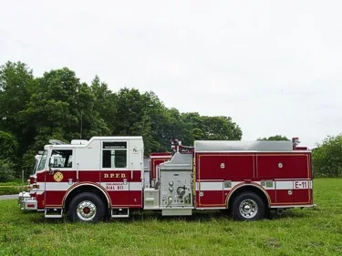 Driver-side profile view of single pumper showing side compartments and wheel area