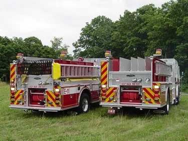 Rear view of two pumpers showing hosebed divider fins and rear chevrons