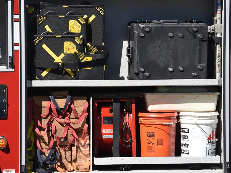 Open side compartment showing tray-mounted tools and a monitor mount panel