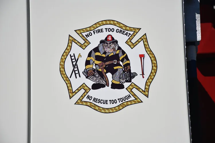 Cab door close-up showing a Maltese-cross style department crest