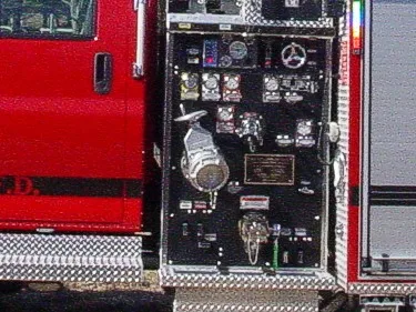 Pump panel close-up showing gauges, valves, intake fittings, and control levers.