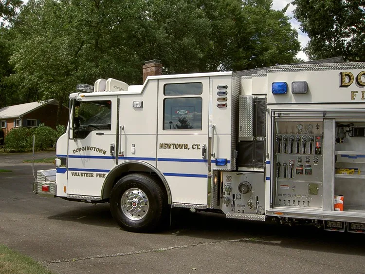 Driver-side profile with open pump panel showing gauges, valves, and controls