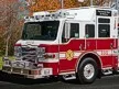 Pierce rescue pumper driver-side profile showing pump panel, roof ladders, and body compartments