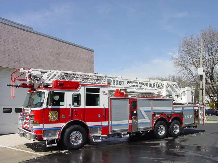 Driver-side view showing the ladder bed, side compartment doors, and rear platform section.