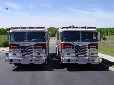 Head-on front view showing two similar pumpers parked side by side