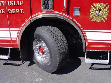 Front wheel and fender close-up showing crest badge and wheel area