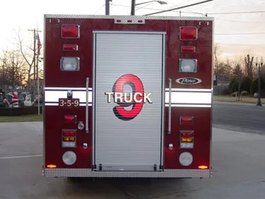 Rear view showing rear roll-up door, warning lights, and lower step