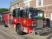 Wide front left view of the parked pumper showing bumper, cab, and body compartments.