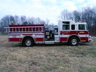 Driver-side profile view showing side hosebed rails and pump panel area