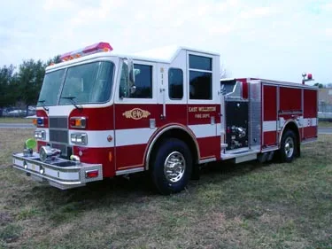 Front-right exterior view showing open side compartment and cab corner