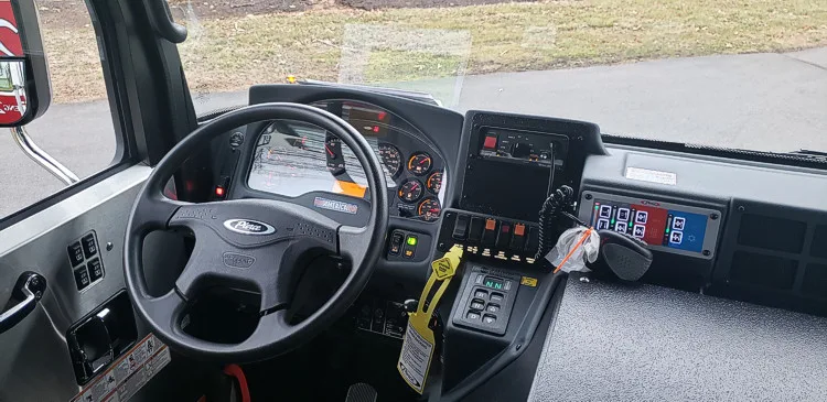 Driver cockpit view showing steering wheel, dashboard, and control console