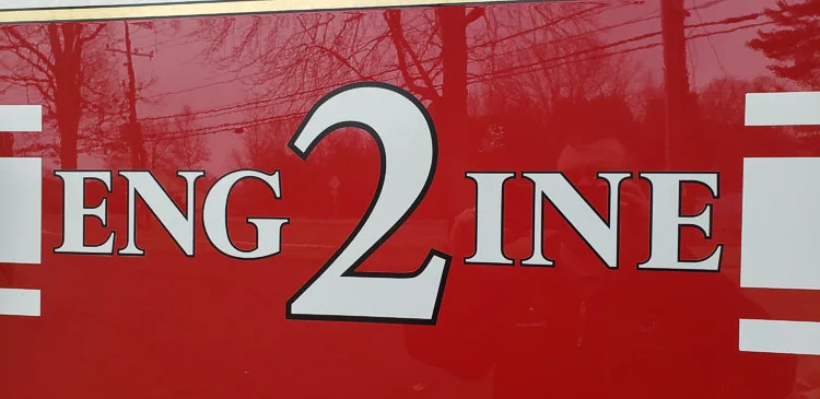 Body side close-up showing raised engine lettering on red panel