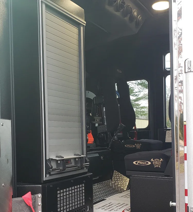 Open rear cab door view showing walk-through access and seat area