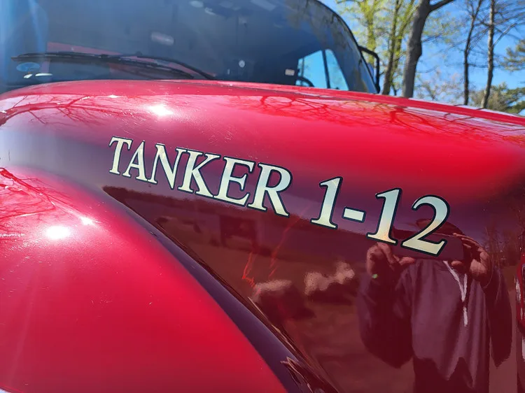 Hood close-up showing raised tanker unit lettering on red paint