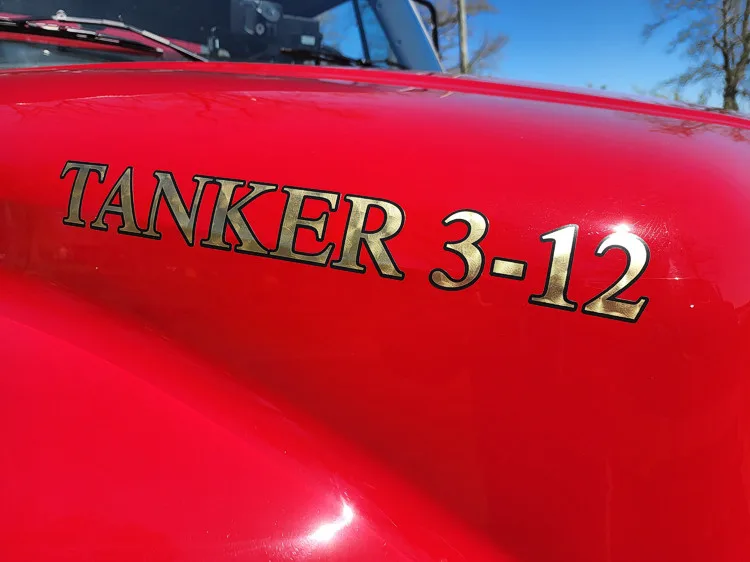 Hood close-up showing raised tanker unit lettering from side angle