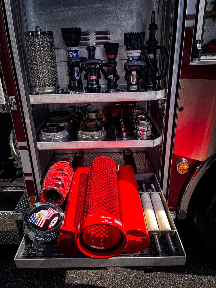 Open lower tray showing folded red hose and equipment pieces