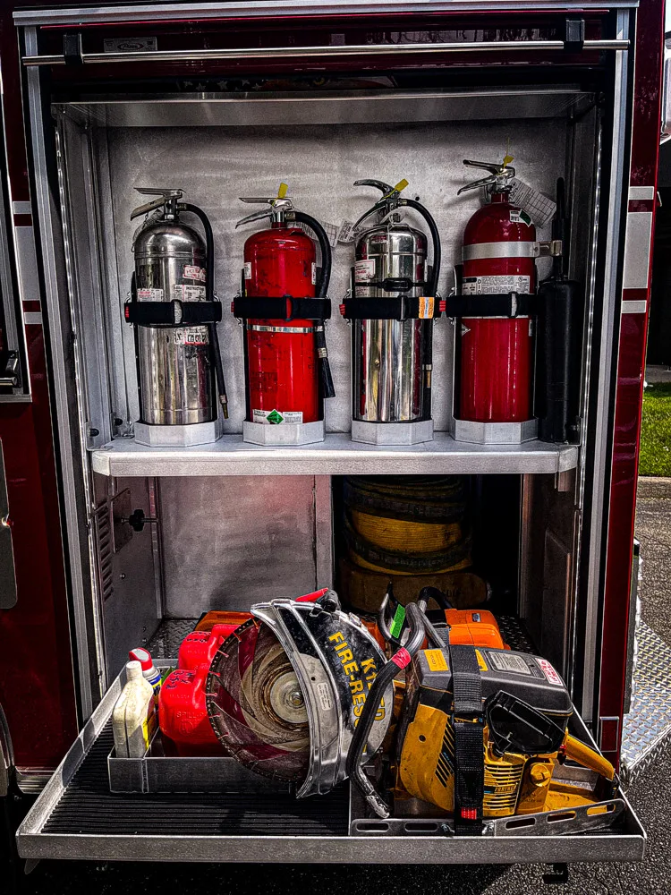 Open side compartment showing extinguishers and equipment bags