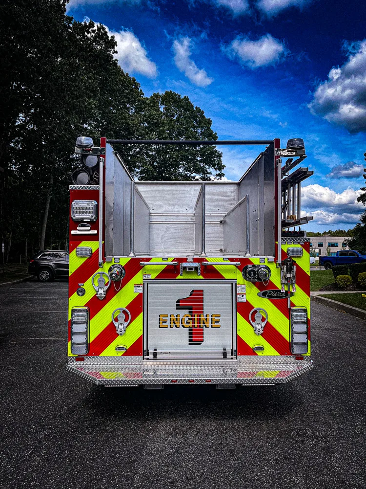Rear view showing red-and-yellow chevrons and upper hosebed opening
