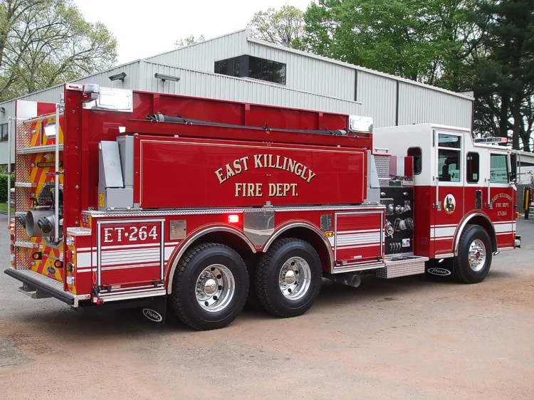 Full right-side profile showing long compartment body, rear dual-axle wheel area, and top hose storage.