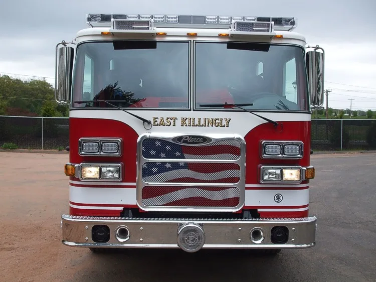Head-on front view showing the chrome bumper, grille with flag-style insert, and windshield light bar.