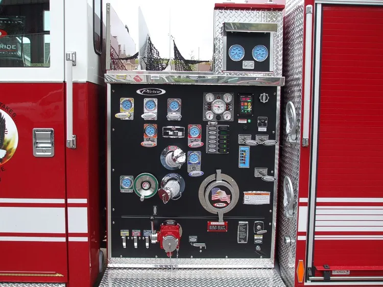 Close-up of the midship pump panel with gauges, valves, intake controls, and labeled switch bank.