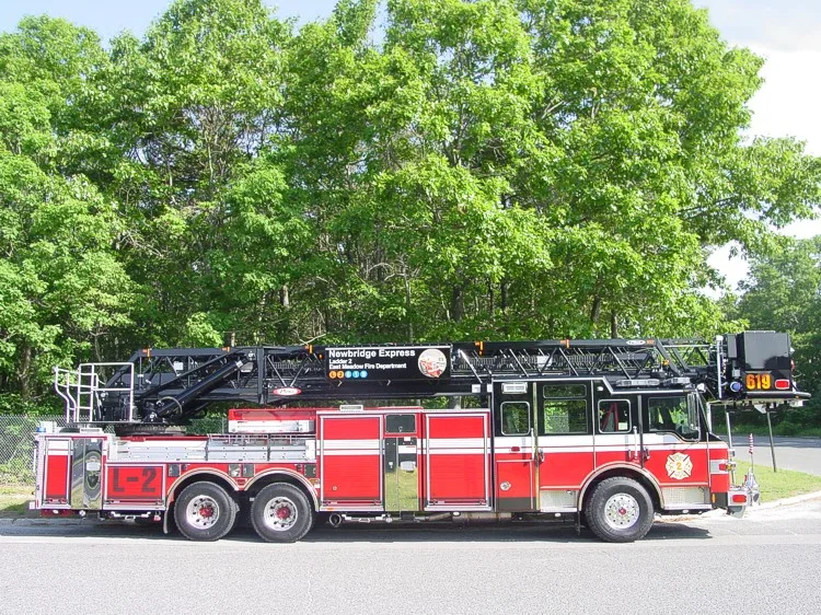 Driver-side full profile showing the stowed aerial ladder, bucket section, and tandem wheel layout.