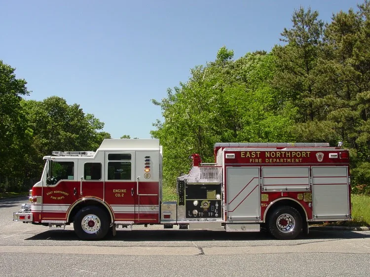 Driver-side profile view showing exposed pump panel, side compartments, and wheel area
