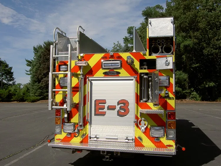 Rear view showing chevron striping, rear door panel, and upper hosebed area