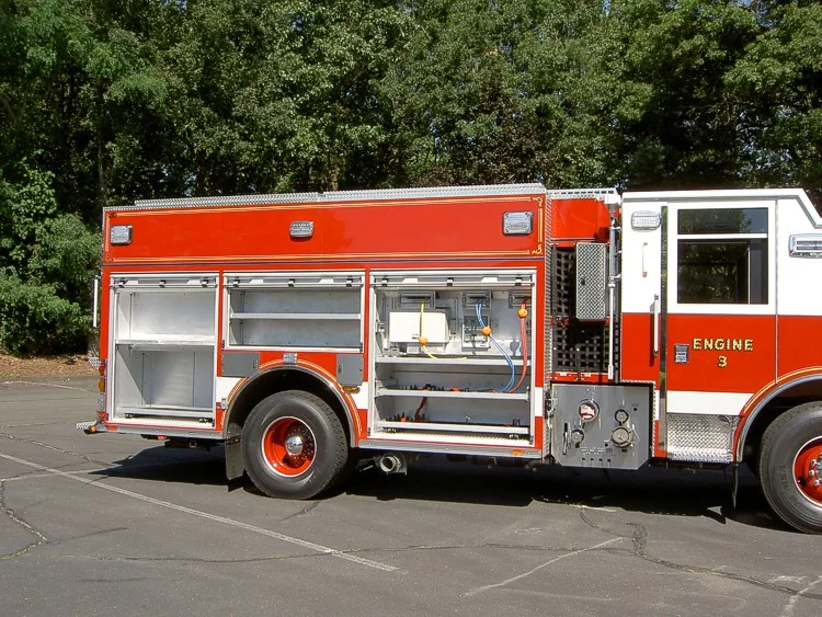 Driver-side profile with open compartments showing shelving and equipment bays