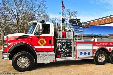 Driver-side profile showing rescue pumper body, pump panel, and wheel area