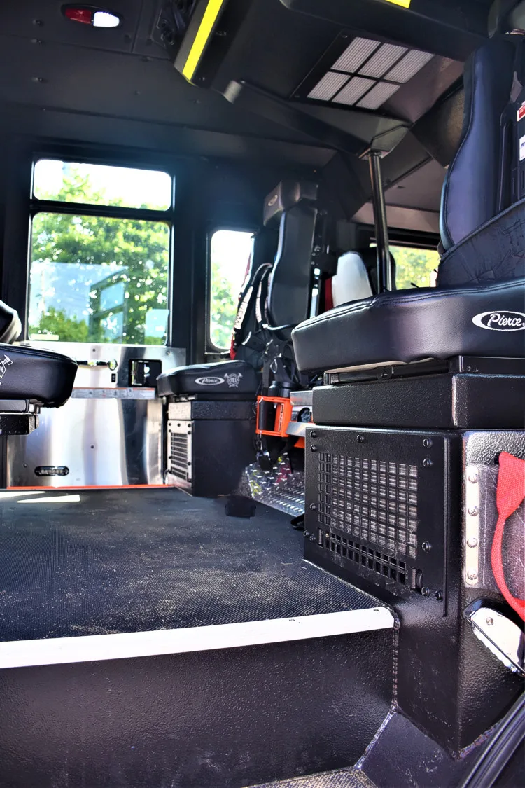 Cab interior rear view showing seat row and side equipment cabinet