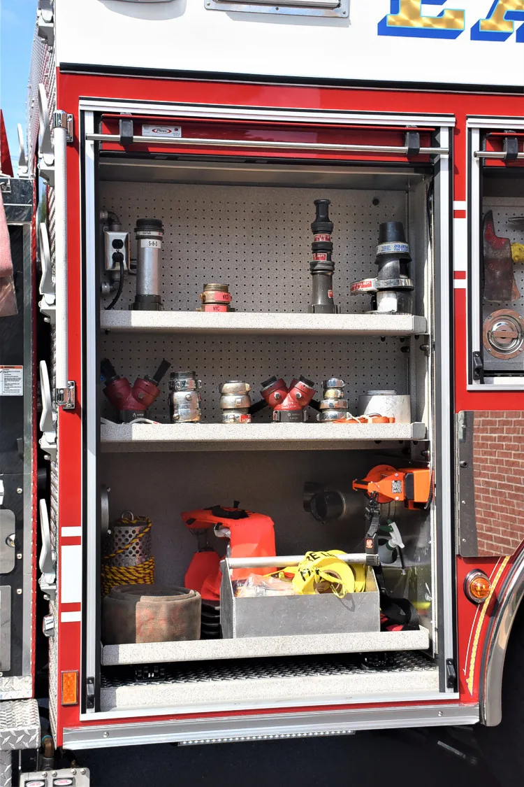 Open side compartment showing extinguisher and bottle storage on shelves