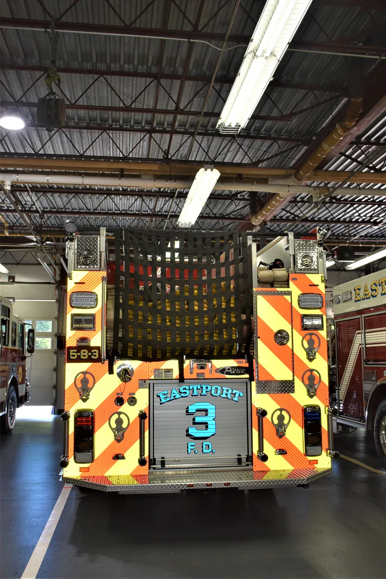 Rear view showing red-and-yellow chevrons and hosebed opening