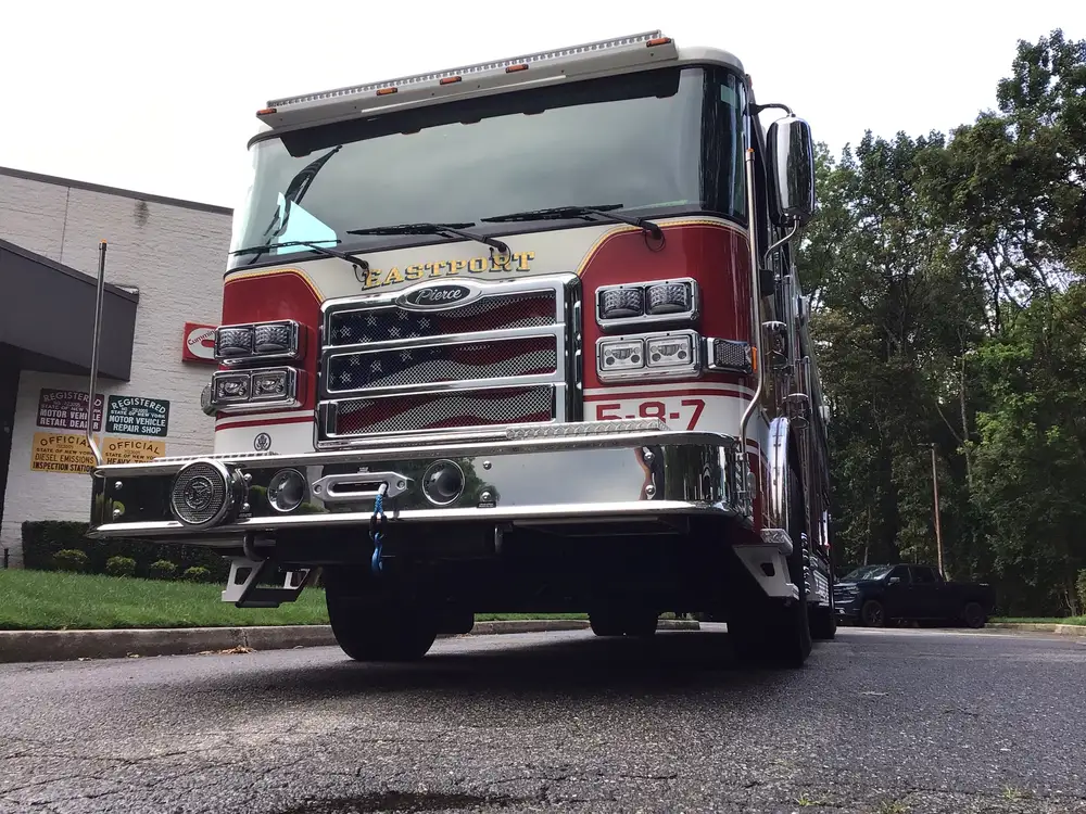 Front-left exterior view showing grille, bumper, and warning lights