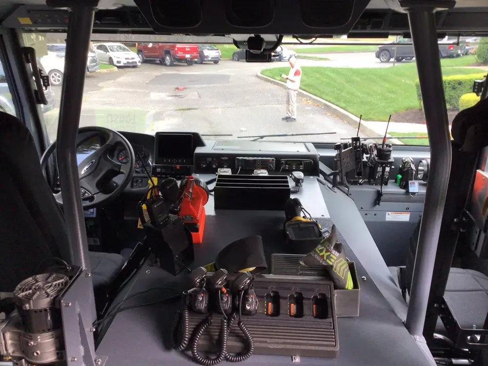 Cab interior wide view showing steering wheel, center console, and radios
