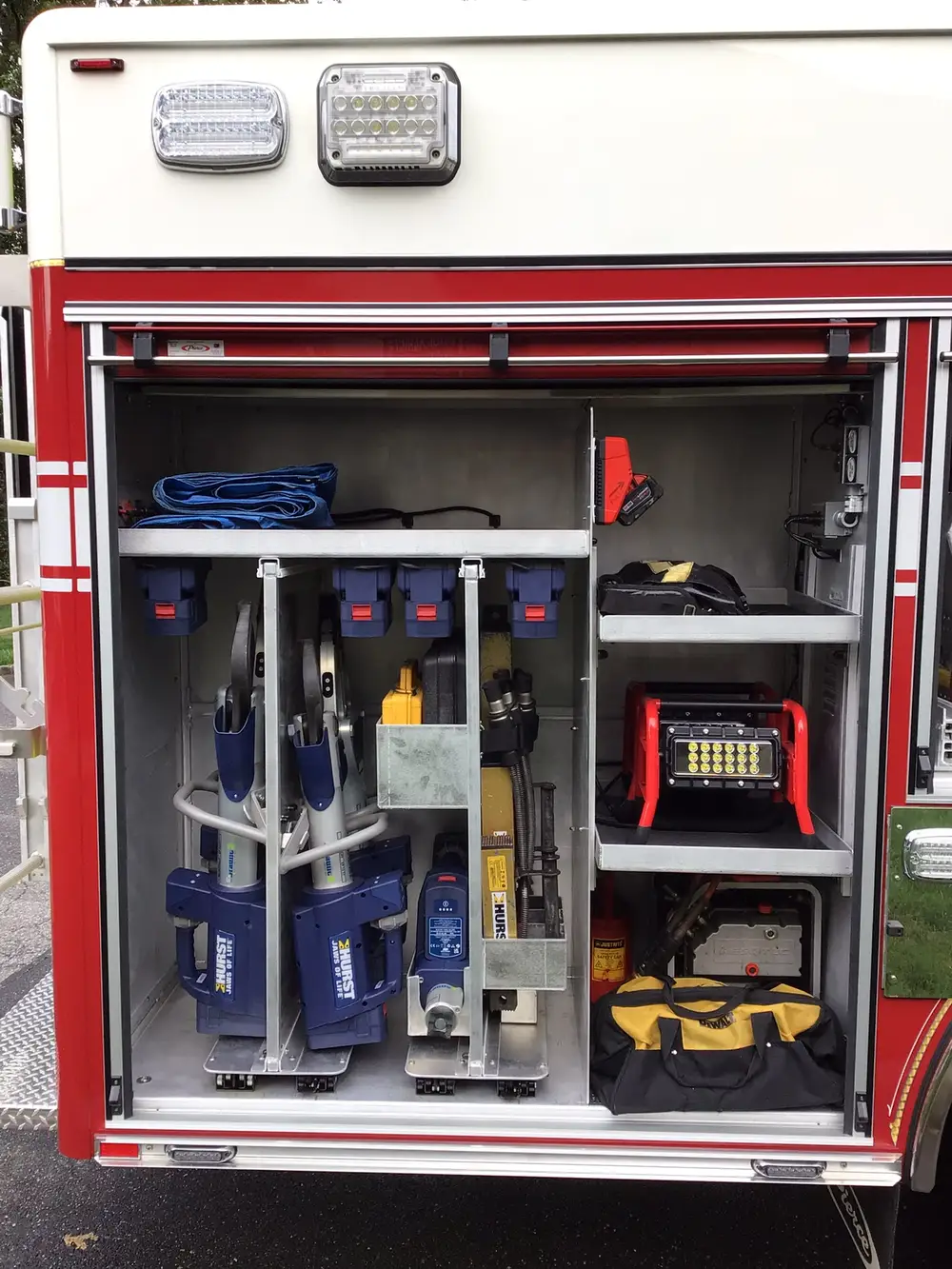 Rear-side compartment with hydraulic rescue tools, scene light, and gear bag