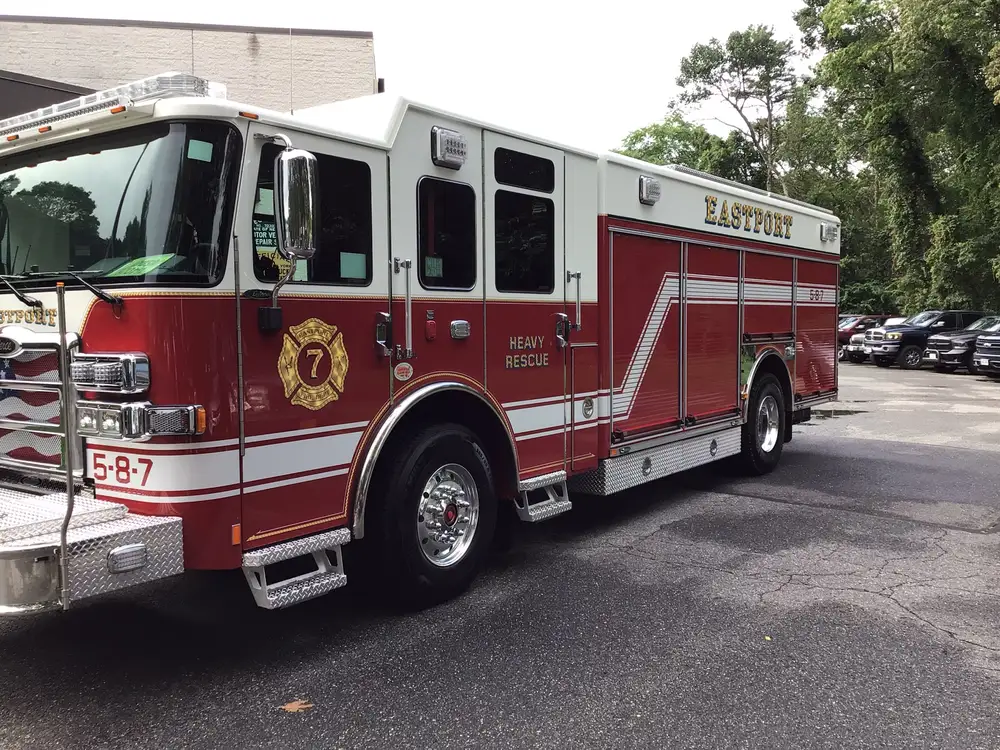 Rear-right exterior view showing open side compartments and body tools